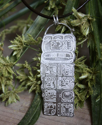 Pendentif avec le calendrier maya montrant une date calculée avec le compte long