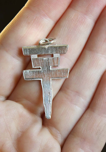 Tokio Hotel, pendentif logo croix du groupe pop rock en argent