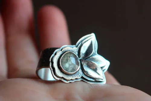 Fleurir sous l’univers, bague fleur et pétales en argent et saphir transparent