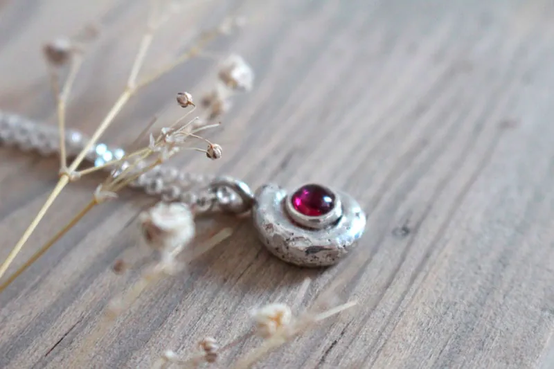 Le berceau de la vie, collier nautilus Ammonite et pierre de naissance en argent et rubis