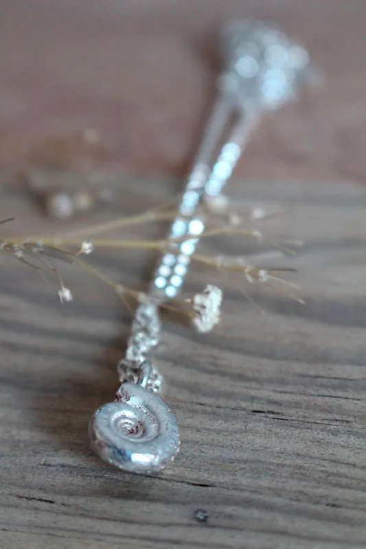 Le berceau de la vie, collier nautilus Ammonite et pierre de naissance en argent et rubis