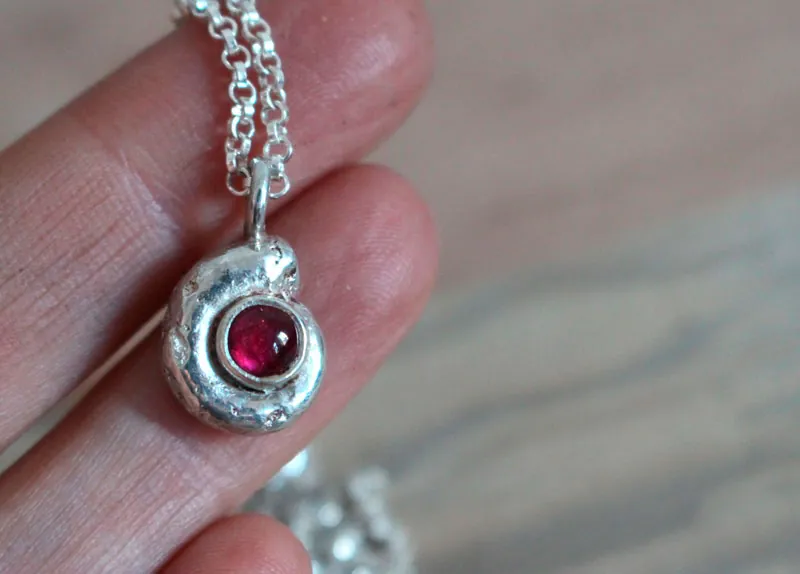 Le berceau de la vie, collier nautilus Ammonite et pierre de naissance en argent et rubis