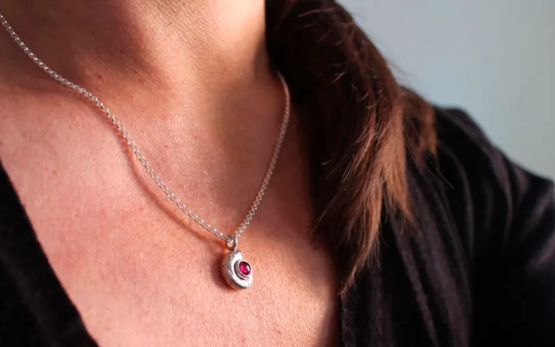 Le berceau de la vie, collier nautilus Ammonite et pierre de naissance en argent et rubis