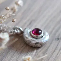 Le berceau de la vie, collier nautilus Ammonite et pierre de naissance en argent et rubis