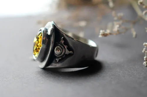 Un halo dans l’obscurité, bague soleil en argent et ambre