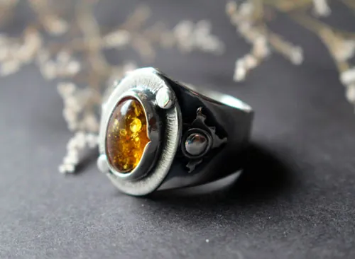 Un halo dans l’obscurité, bague soleil en argent et ambre