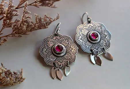 Boucles d’oreilles la rose d’orient evoquant la fleur avec sa gravure et son rubis rose