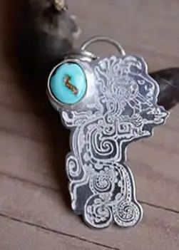 Pendentif Kukulkan qui montre le dieu serpent à plumes des Mayas